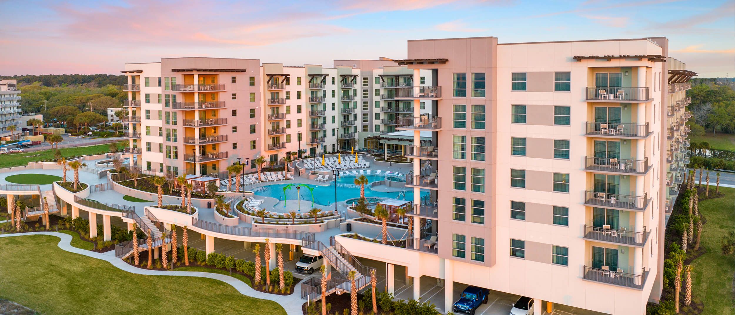 Resort pool and beachfront villas at sunset​
